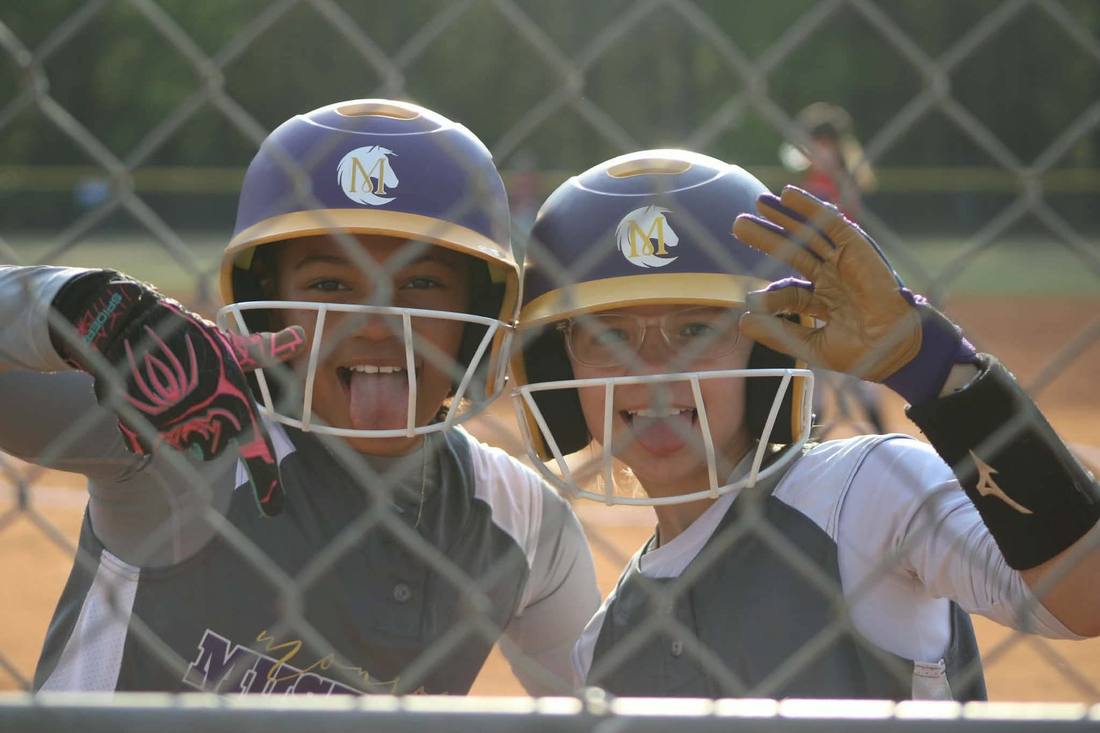 Two Mustangs players smiling in helmets